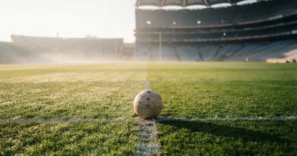 A ball on the centre spot of a grass pitch in morning light